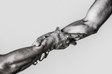 Helping hand outstretched, isolated arm, salvation. Close up help hand. Two hands, helping arm of a friend, teamwork. Black and white