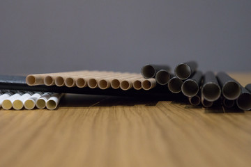 Bundle of paper straws white, brown and black in a wood table display background, great for environmental purpose