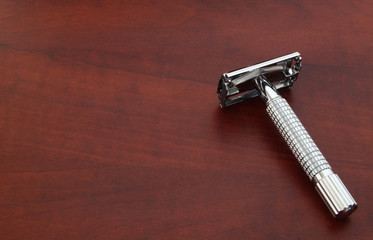 Metallic razor on wooden background
