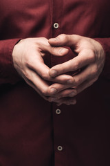 partial view of man gesturing with clenched hands, human emotion and expression concept