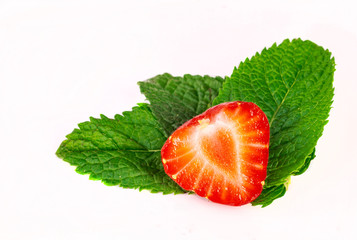 Przekrojona truskawka na zielonych lisciach. Truskawki  i mieta.  Truskawk an bialym tle. © ff25