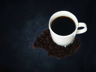 Obraz na płótnie Canvas Black coffee cup and bean on black granite background