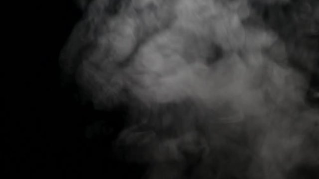 Selective focus of smoke rising on dark background 