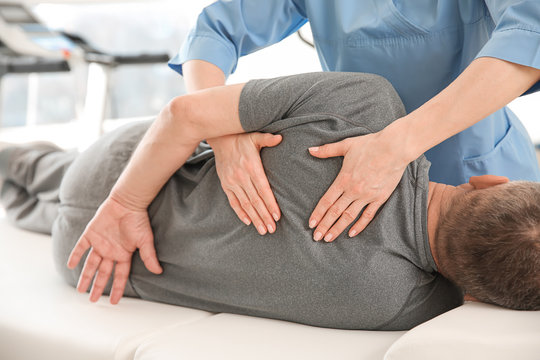 Physiotherapist working with mature patient in rehabilitation center