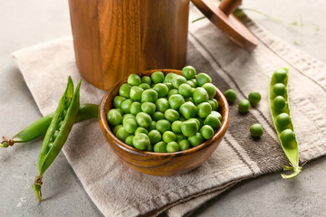 Bowl with tasty fresh peas on grey background