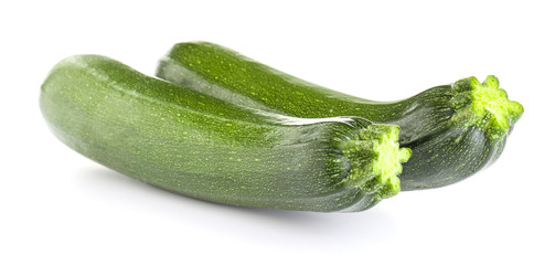Fresh zucchini squashes on white background