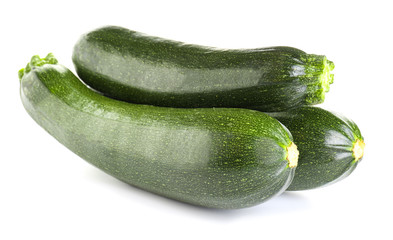 Fresh zucchini squashes on white background