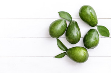 Fresh ripe avocados on white wooden background