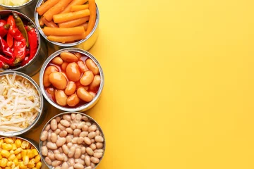 Photo sur Plexiglas Manger Boîtes de conserve avec différents aliments sur fond de couleur