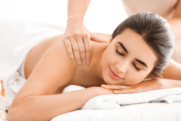 Fototapeta na wymiar Beautiful young woman receiving massage in spa salon