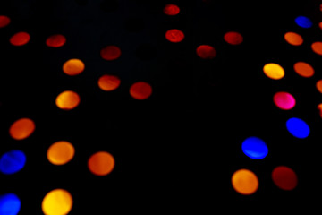 Abstract background with confetti on isolated black background. A place for your text. Blue, orange, yellow, red confetti.