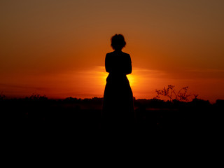 girl watching the sunset in the field