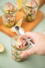 Frau isst Friesischer Nordseekrabben Salat Glas Becher mit Gurken, Radieschen, Zwiebeln, Dill und Zitronen 