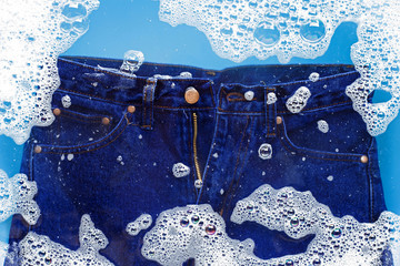Jeans soak in powder detergent water dissolution. Laundry concept
