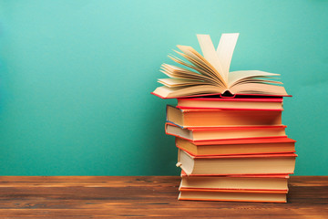 Opened Book on a pile of old books on blue background