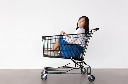 happy asian woman with shopping cart ready for shopping on sale