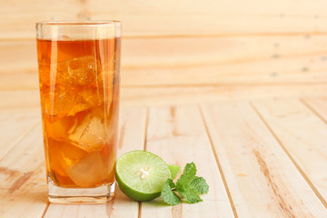 ice tea with slice of lemon in glass on the wooden background