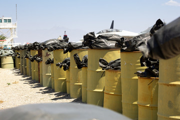 A protective barrier of heavy oil drum barrels on a military base