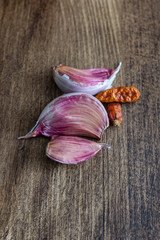 Top view on close-up of garlic and cayenne on dark wood background with copy space