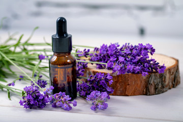 lavender herbal oil and flowers on wooden background - obrazy, fototapety, plakaty