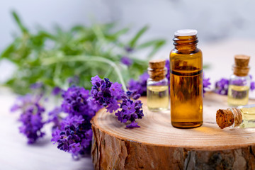 Obraz na płótnie Canvas herbal essential oil bottles and fresh lavender flowers