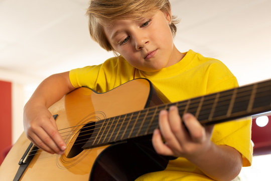 Boy playing guitar in a classroom