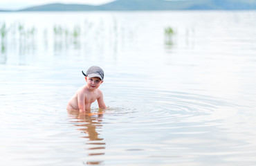 small boy with blonde hair have fun in sea swimming, summertime, hardening