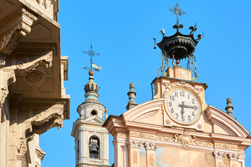 Fototapeta na wymiar MONDOVI, ITALY - AUGUST 15, 2016: Saint Peter and Paul church clock and bell tower with automaton in a summer day, clear blue sky in Mondovi, Italy.