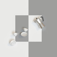 traditional Italian coffee maker and ceramic cups on a white and gray background.