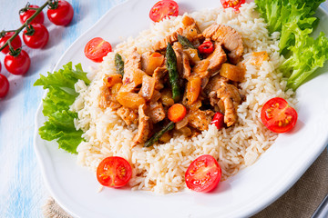 Turkey fricassee on rice with asparagus and paprika