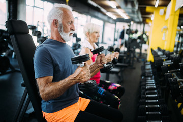 Happy fit mature man in gym working out to stay healthy