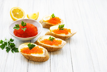 Red caviar in bowl and sandwiches