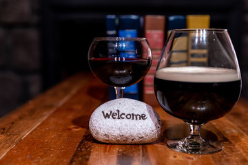 Composition of two vine glasses, books and a stone with 