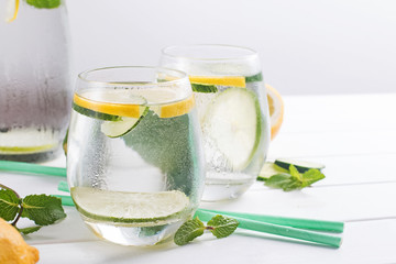 Water infused with mint, lemon and cucucmber on the white wooden table