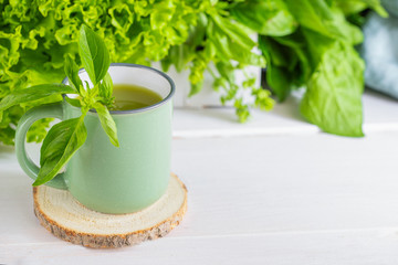 Freshly blended green smoothie in a ceramic cup on the table. Detox vegetable juice. Healthy...