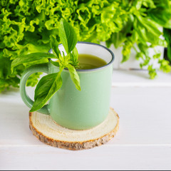 Freshly blended green smoothie in a ceramic cup on the table. Detox vegetable juice. Healthy...