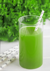 Freshly blended green smoothie in in a glass with straws on the table. Detox vegetable juice. Healthy lifestyle concept. Raw drink for vegan diet.