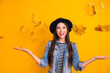 Portrait of her she nice-looking winsome attractive lovely optimistic cheerful cheery straight-haired lady throwing leaves isolated over bright vivid shine yellow background
