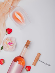 Creative summer flat lay with rose wine, delicious strawberries and beautiful peonies
