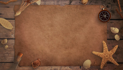 A piece of old paper on a wooden table, surrounded by old sea things. Top view, flat lay, mockup.