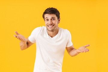 Photo of handsome man in basic t-shirt smiling at camera and throwing up arms