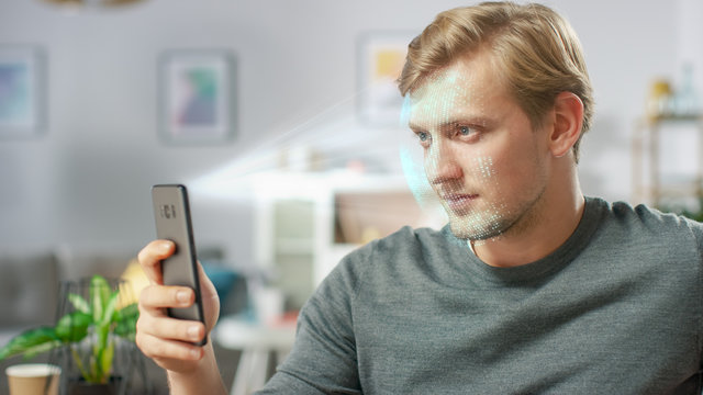 Young Man Identified by Biometric Facial Recognition Scanning Process from His Smartphone. Futuristic Concept: Projector Identifies Individual by Illuminating Face by Dots and Scanning with Laser