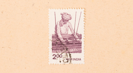 INDIA - CIRCA 1970: A stamp printed in India shows a man working a loom, circa 1970