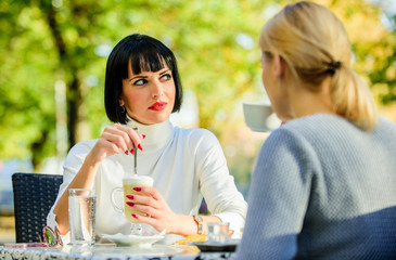 Girls friends drink coffee talk. Conversation women cafe terrace. Friendship friendly relations. Discussing rumors. Trustful communication. Friendship sisters. Friendship meeting. Closest people