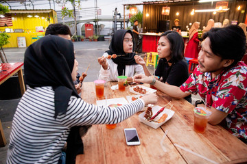 Young people lunch together when hanging out on the rooftop outdoor foodcourt