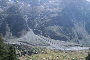 A village in the mountains with high mountain in background