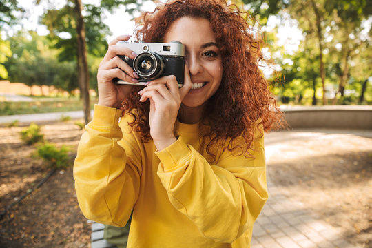 Happy young girl with red curly hair