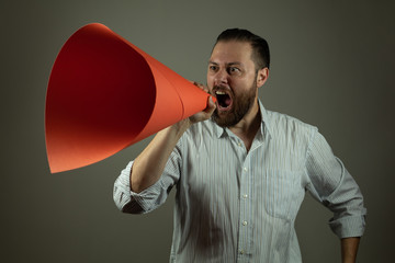 Business man in casual shirt announcing something at a megaphone made of paper