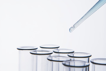 Pipette dropping liquid into cells of container