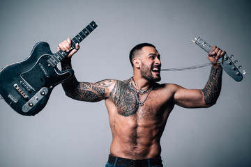 sexy abs of tattoo man broke guitar. rock concert. confidence charisma. sport fitness, health....